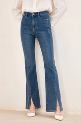 a lady in blue jeans with split hem styled with white high heel